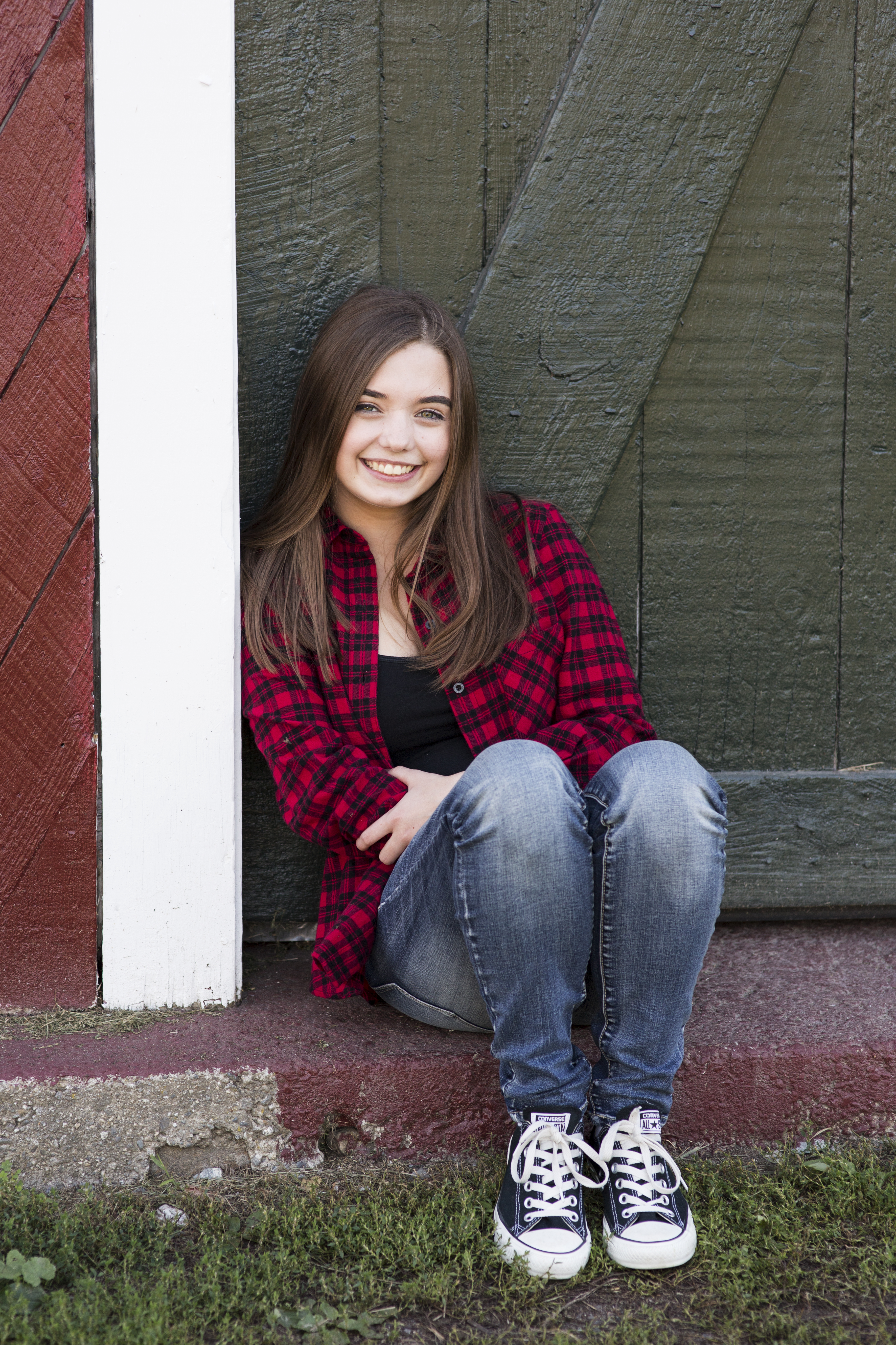 senior photos of girl in front of barn