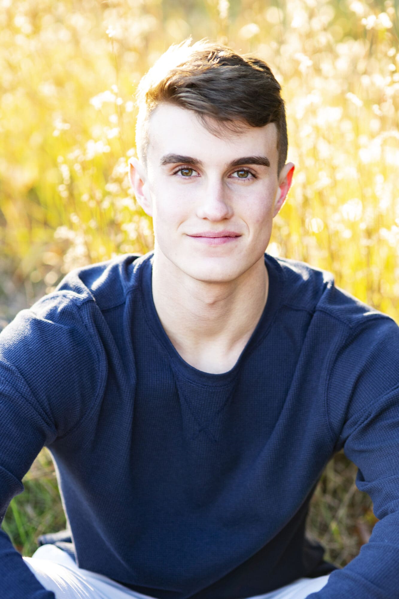 senior boy portrait in golden grass field