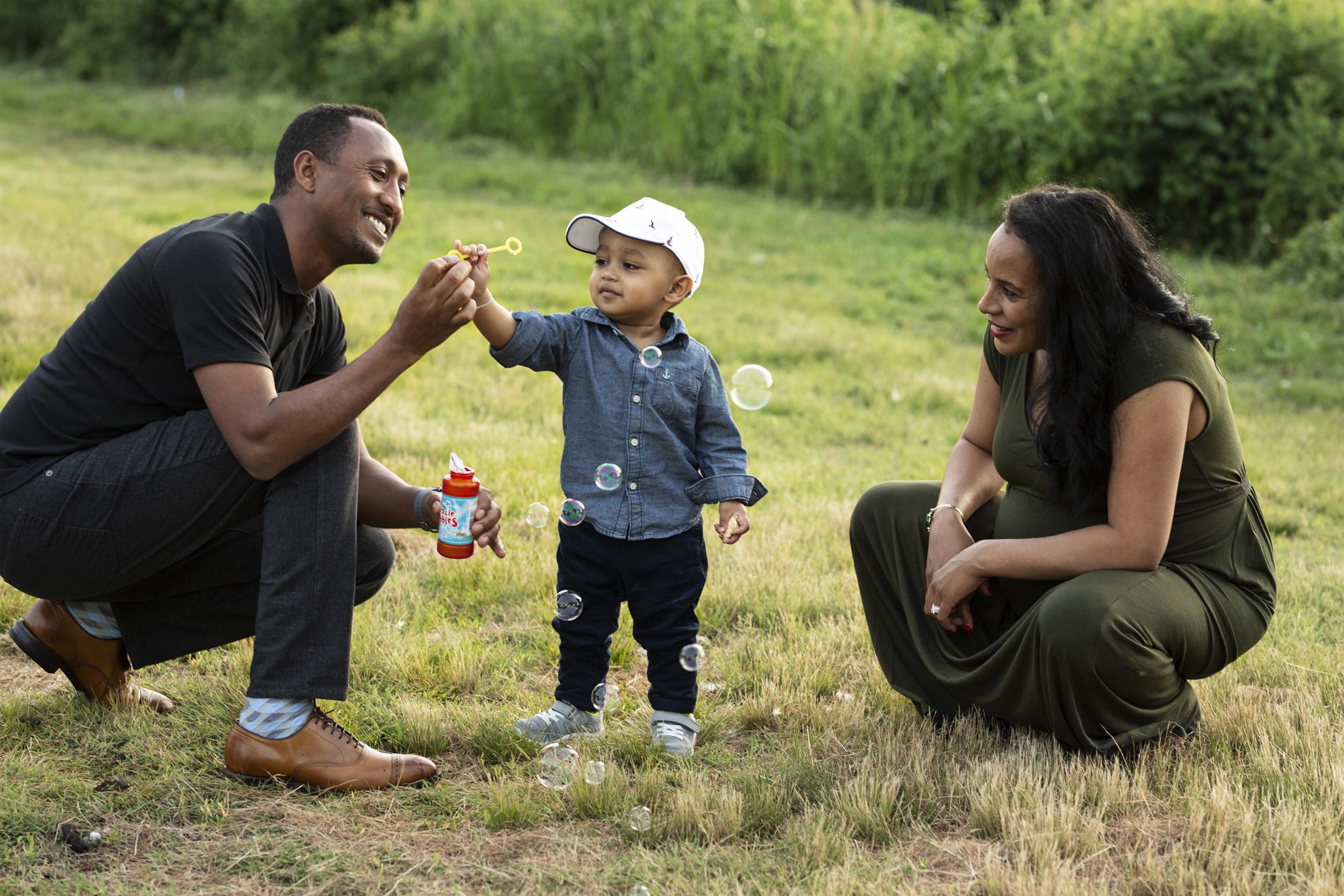 family maternity photo mom dad toddler boy blowing bubbles lifestyle boston massachusetts herter park